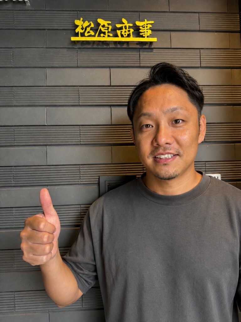 有限会社松原商事　松原佳祐さん。店舗前にて。