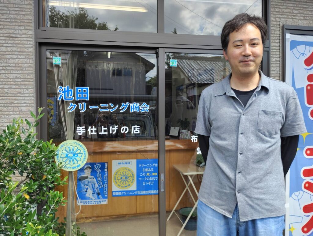 池田クリーニング商会の池田拓真さん。店舗前にて。
