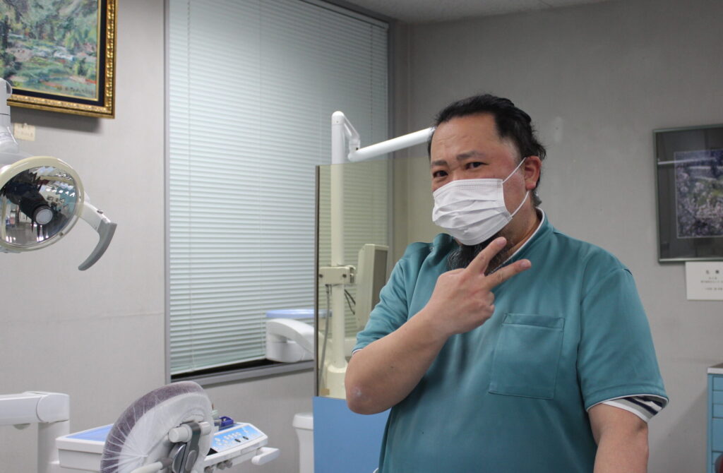 青木歯科医院 院長・青木陽太郎氏。診療室にてピース。