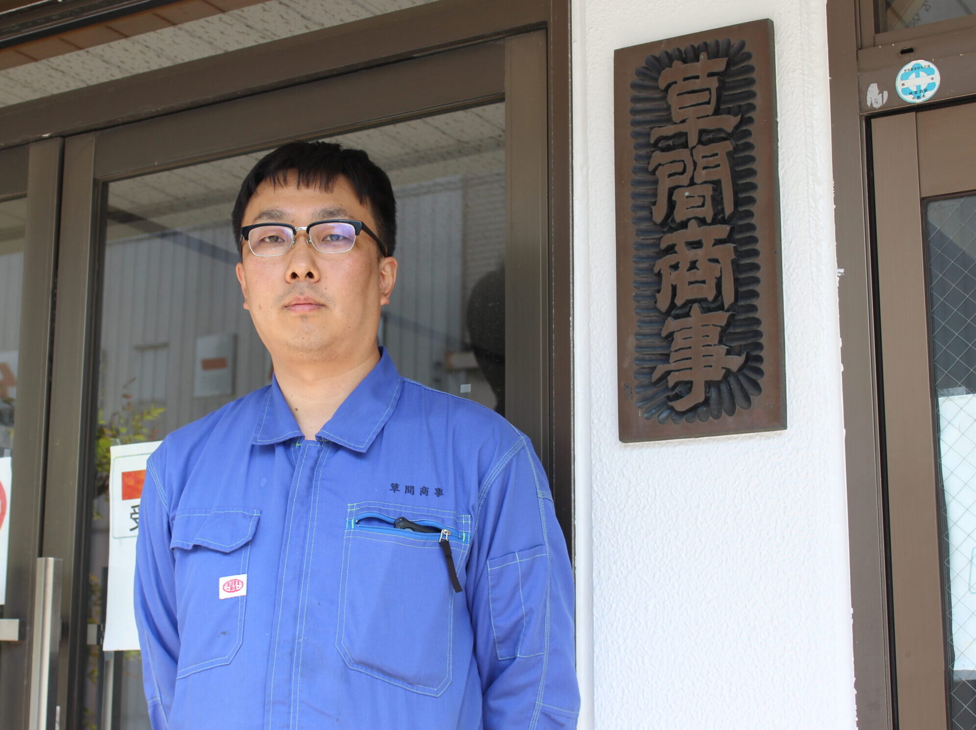 有限会社草間商事 小林洋貴 専務。社屋入口にて。