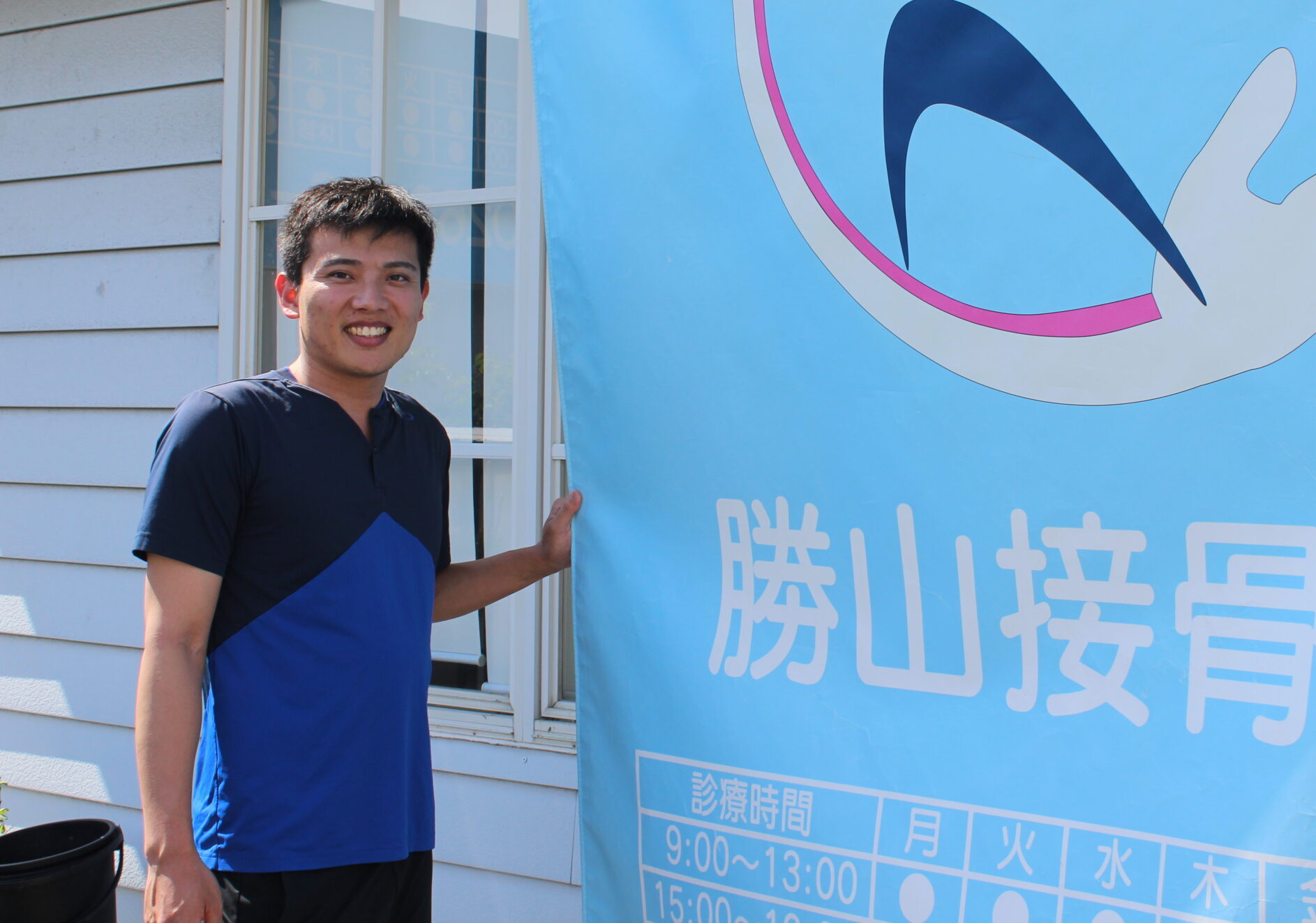 勝山接骨院 勝山晃喜さん。看板前にて。
