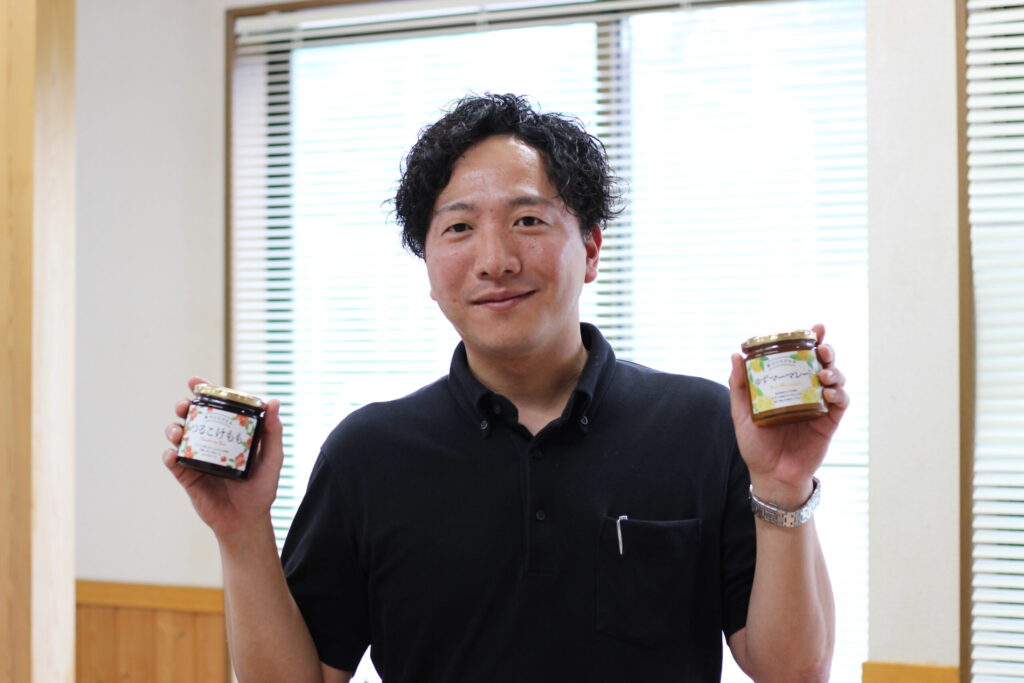 中高果実加工 酒井智正さん。ジャムを手に。