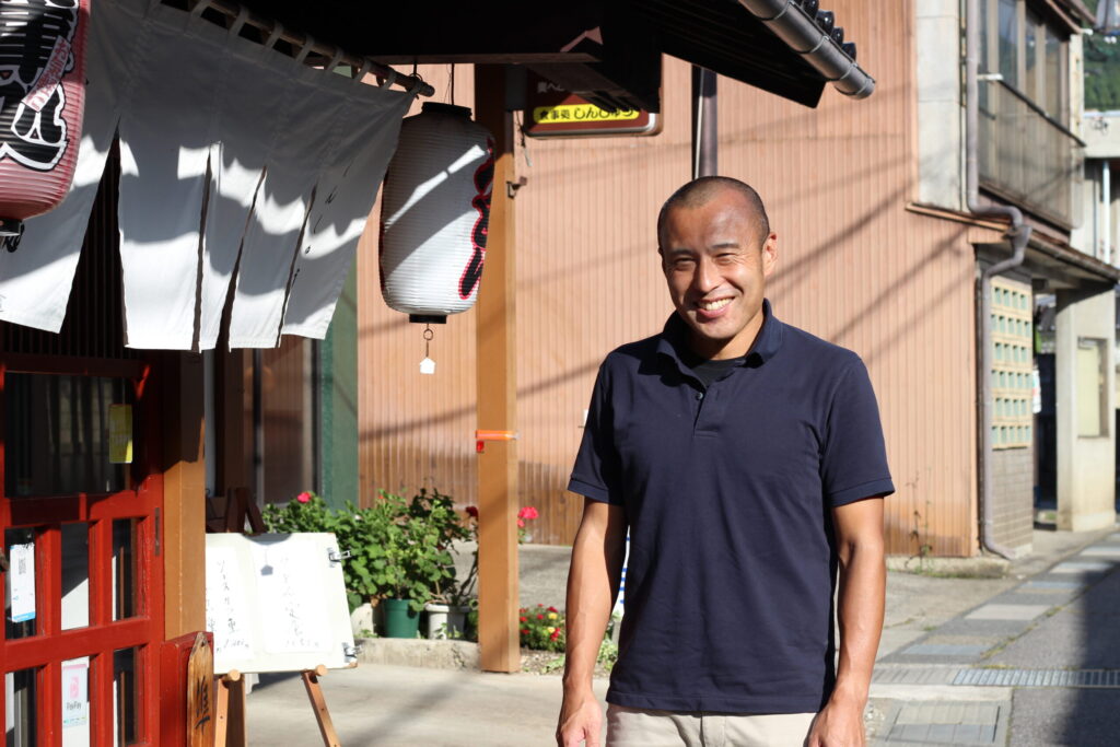 食事処しんしゅう 山崎稔明さん。店舗の前にて。