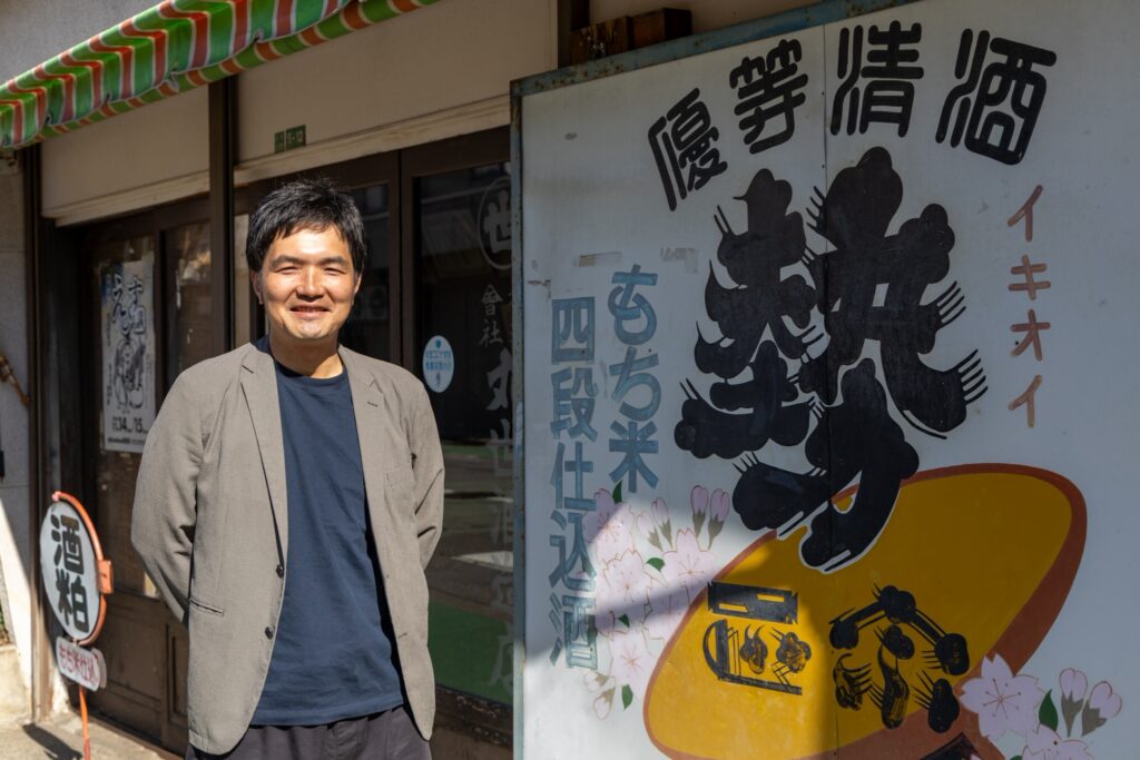 丸世酒造店　関晋司さん。店舗前にて。